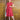 Woman posing in 1950s rouge pink linen blend A-line dress with duck egg embroidery and belt