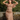 Woman in 1940s beige floral tea dress with flutter sleeves leaning against a stone wall