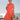 Woman in 1940s salmon pink shirtwaist dress with teal piping posing by the sea