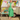 Woman in retro green linen blend A-line dress and cardigan posing outside vintage caravan