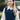 Blonde woman wearing navy blue cable knit tank top layered over white collared shirt